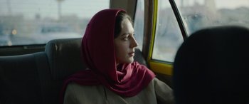Movie still from “Holy Spider” (2022), directed by Ali Abbasi – A woman sitting in a car wearing a headscarf; Close Up shot, Over the shoulder angle