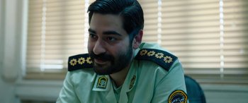 Movie still from “Holy Spider” (2022), directed by Ali Abbasi – A person wearing a military uniform; Close Up shot, Over the shoulder angle