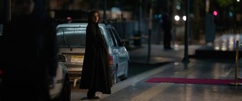 Movie still from “Holy Spider” (2022), directed by Ali Abbasi – A woman standing on the side of the street; Wide shot, Over the shoulder angle