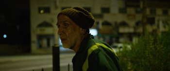 Movie still from “Holy Spider” (2022), directed by Ali Abbasi – An older man wearing a green and yellow shirt and a hat; Close Up shot, Low angle