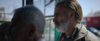 Movie still from “Holy Spider” (2022), directed by Ali Abbasi – A man with a gray beard is talking to another man; Close Up shot, Over the shoulder angle