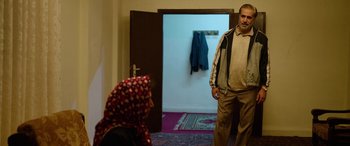 Movie still from “Holy Spider” (2022), directed by Ali Abbasi – A man and a woman are standing in front of a door; Medium shot, Over the shoulder angle