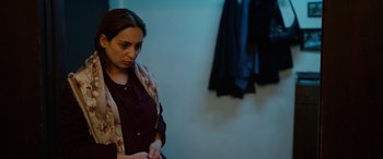 Movie still from “Holy Spider” (2022), directed by Ali Abbasi – A woman is looking down at her hands; Medium shot, Over the shoulder angle