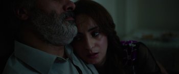 Movie still from “Holy Spider” (2022), directed by Ali Abbasi – A man and a woman sitting next to each other; Close Up shot, High angle