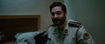 Movie still from “Holy Spider” (2022), directed by Ali Abbasi – A person wearing a military uniform; Close Up shot, Over the shoulder angle
