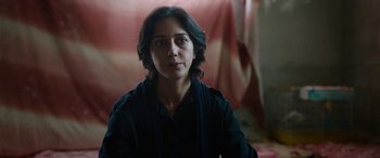 Movie still from “Holy Spider” (2022), directed by Ali Abbasi – A woman in a black shirt is looking at the camera; Close Up shot, Over the shoulder angle