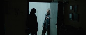 Movie still from “Holy Spider” (2022), directed by Ali Abbasi – A man and a woman standing in front of an open door; Medium shot, Over the shoulder angle