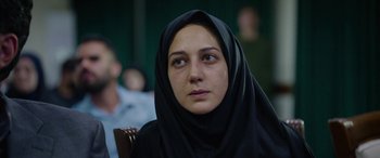 Movie still from “Holy Spider” (2022), directed by Ali Abbasi – A woman wearing a black headscarf looking at the camera; Close Up shot, Over the shoulder angle