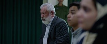 Movie still from “Holy Spider” (2022), directed by Ali Abbasi – An older man sitting next to a young man; Medium shot, Over the shoulder angle