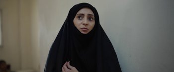 Movie still from “Holy Spider” (2022), directed by Ali Abbasi – A woman in a black veil is looking at the camera; Close Up shot, Overhead angle