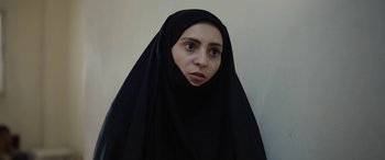 Movie still from “Holy Spider” (2022), directed by Ali Abbasi – A woman in a black veil looking at the camera; Close Up shot, Over the shoulder angle