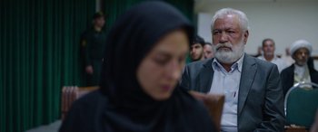 Movie still from “Holy Spider” (2022), directed by Ali Abbasi – An older man and a young woman are sitting in a room; Close Up shot, Over the shoulder angle