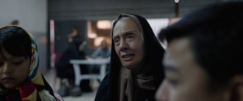 Movie still from “Holy Spider” (2022), directed by Ali Abbasi – An older woman with a black head covering; Close Up shot, Over the shoulder angle