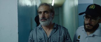 Movie still from “Holy Spider” (2022), directed by Ali Abbasi – A man with grey hair and a gray beard; Close Up shot, Over the shoulder angle