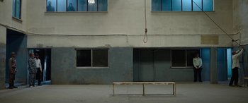Movie still from “Holy Spider” (2022), directed by Ali Abbasi – A rope hanging from the side of a building next to a bench; Extreme Wide shot, High angle