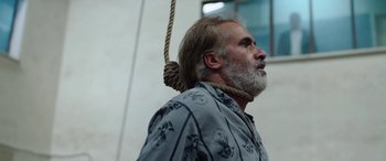 Movie still from “Holy Spider” (2022), directed by Ali Abbasi – A man with a beard hanging from the side of a noose; Close Up shot, Low angle