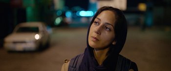 Movie still from “Holy Spider” (2022), directed by Ali Abbasi – A woman with a head scarf looking into the distance; Close Up shot, Over the shoulder angle