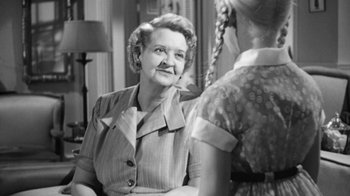 Movie still from “The Bad Seed” (1956), directed by Mervyn LeRoy – An older woman sitting in front of a young girl; Close Up shot, Over the shoulder angle