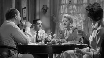 Movie still from “The Bad Seed” (1956), directed by Mervyn LeRoy – A group of people sitting at a table with food; Medium shot, High angle