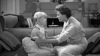 Movie still from “The Bad Seed” (1956), directed by Mervyn LeRoy – An older woman sitting next to a little girl; Medium shot, High angle