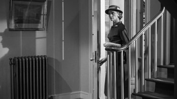 Movie still from “The Bad Seed” (1956), directed by Mervyn LeRoy – An older woman standing on the stairs of a house; Wide shot, Low angle