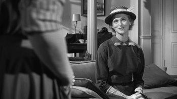 Movie still from “The Bad Seed” (1956), directed by Mervyn LeRoy – An old photo of a woman sitting on a couch; Medium shot, Over the shoulder angle