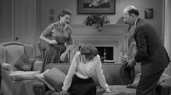 Movie still from “The Bad Seed” (1956), directed by Mervyn LeRoy – A group of people in a living room with a fireplace; Medium shot, High angle