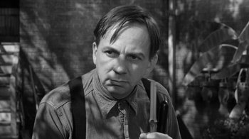 Movie still from “The Bad Seed” (1956), directed by Mervyn LeRoy – Black and white photograph of a man holding a knife; Close Up shot, Low angle