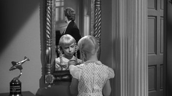 Movie still from “The Bad Seed” (1956), directed by Mervyn LeRoy – A little girl looking in the mirror and brushing her hair; Close Up shot, Over the shoulder angle