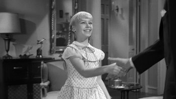 Movie still from “The Bad Seed” (1956), directed by Mervyn LeRoy – A young girl is shaking hands with an older man; Medium shot, Over the shoulder angle