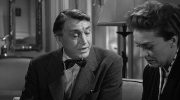 Movie still from “The Bad Seed” (1956), directed by Mervyn LeRoy – An older man wearing a suit talking to a woman; Close Up shot, Over the shoulder angle