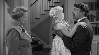 Movie still from “The Bad Seed” (1956), directed by Mervyn LeRoy – An old photo of two women and a little girl; Medium shot, Over the shoulder angle