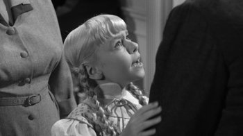 Movie still from “The Bad Seed” (1956), directed by Mervyn LeRoy – A little girl with pigtails is looking up; Close Up shot, High angle