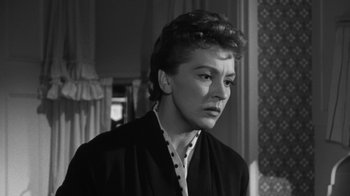 Movie still from “The Bad Seed” (1956), directed by Mervyn LeRoy – An old black and white photo of a woman looking at the camera; Close Up shot, Low angle