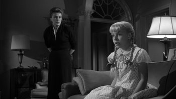 Movie still from “The Bad Seed” (1956), directed by Mervyn LeRoy – An old photo of a woman and a little girl; Medium shot, Over the shoulder angle
