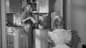 Movie still from “The Bad Seed” (1956), directed by Mervyn LeRoy – An old photo of a woman and a little girl; Medium shot, Over the shoulder angle