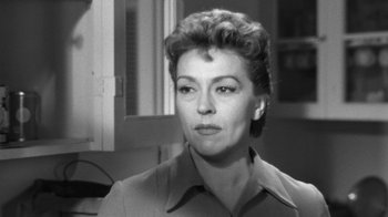 Movie still from “The Bad Seed” (1956), directed by Mervyn LeRoy – An old black and white photo of a woman looking at the camera; Close Up shot, Over the shoulder angle
