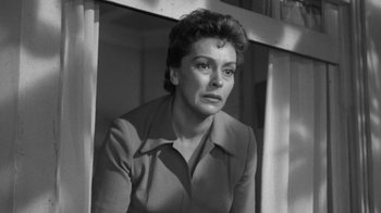 Movie still from “The Bad Seed” (1956), directed by Mervyn LeRoy – An old black and white photo of a woman looking sad; Close Up shot, Low angle