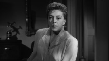 Movie still from “The Bad Seed” (1956), directed by Mervyn LeRoy – An old black and white photo of a woman; Close Up shot, Low angle