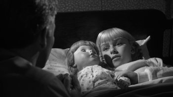 Movie still from “The Bad Seed” (1956), directed by Mervyn LeRoy – Two dolls laying in a bed next to each other; Close Up shot, Over the shoulder angle