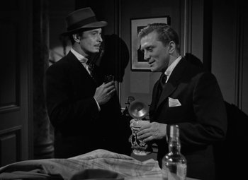 Movie still from “The Bad and the Beautiful” (1952), directed by Vincente Minnelli – Two men in suits and hats are looking at each other in a room; Medium shot, Low angle