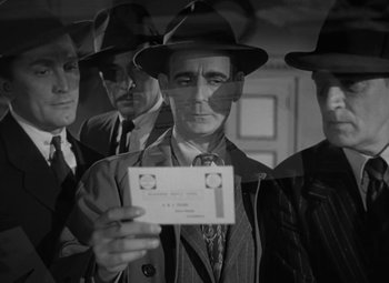 Movie still from “The Bad and the Beautiful” (1952), directed by Vincente Minnelli – A group of men standing next to each other holding papers; Close Up shot, Low angle