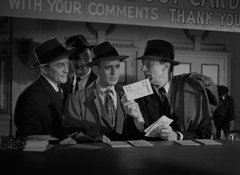 Movie still from “The Bad and the Beautiful” (1952), directed by Vincente Minnelli – A black and white photo of a group of men in suits and hats; Medium shot, Low angle