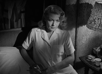 Movie still from “The Bad and the Beautiful” (1952), directed by Vincente Minnelli – A black - and - white photo of a woman holding a pen; Medium shot, Low angle