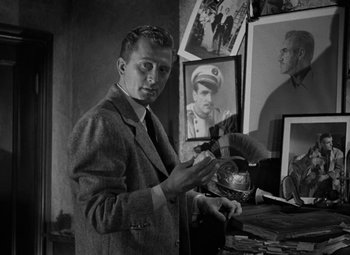 Movie still from “The Bad and the Beautiful” (1952), directed by Vincente Minnelli – A black and white photo of a man in a suit and tie; Medium shot, Over the shoulder angle