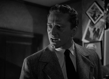 Movie still from “The Bad and the Beautiful” (1952), directed by Vincente Minnelli – Black and white photograph of a man wearing a suit; Close Up shot, Low angle