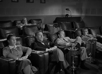 Movie still from “The Bad and the Beautiful” (1952), directed by Vincente Minnelli – A black and white photo of people sitting in a movie theater; Wide shot, High angle