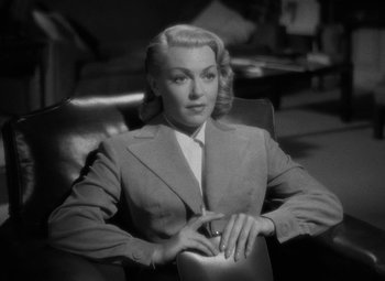 Movie still from “The Bad and the Beautiful” (1952), directed by Vincente Minnelli – A black and white photo of a woman sitting in a chair; Medium shot, High angle