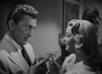 Movie still from “The Bad and the Beautiful” (1952), directed by Vincente Minnelli – A man and a woman are holding glasses of wine; Medium shot, Over the shoulder angle