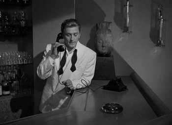 Movie still from “The Bad and the Beautiful” (1952), directed by Vincente Minnelli – A black and white photo of a man talking on a phone; Medium shot, Low angle